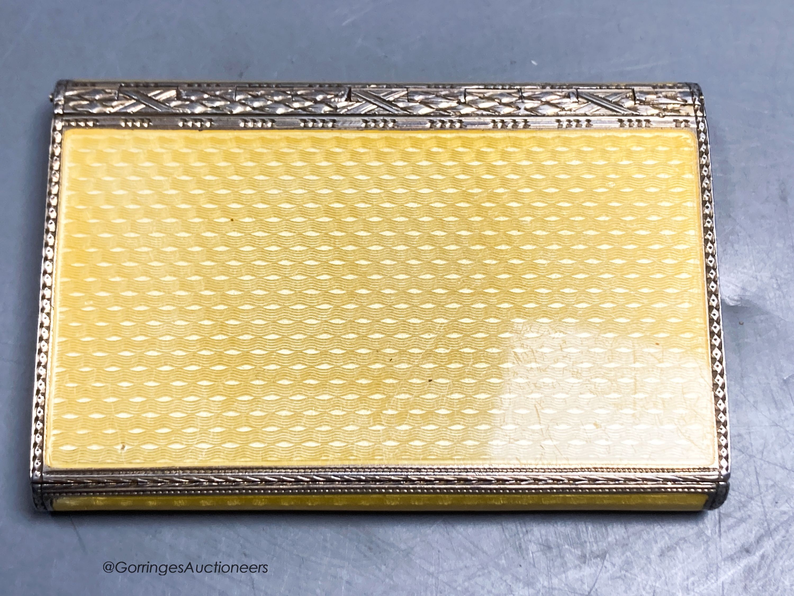 A 1920's continental silver and yellow guilloche enamel rectangular box and hinged cover, import marks for P.H. Vogel & Co, London, 1927, 79mm by 53mm by 10mm